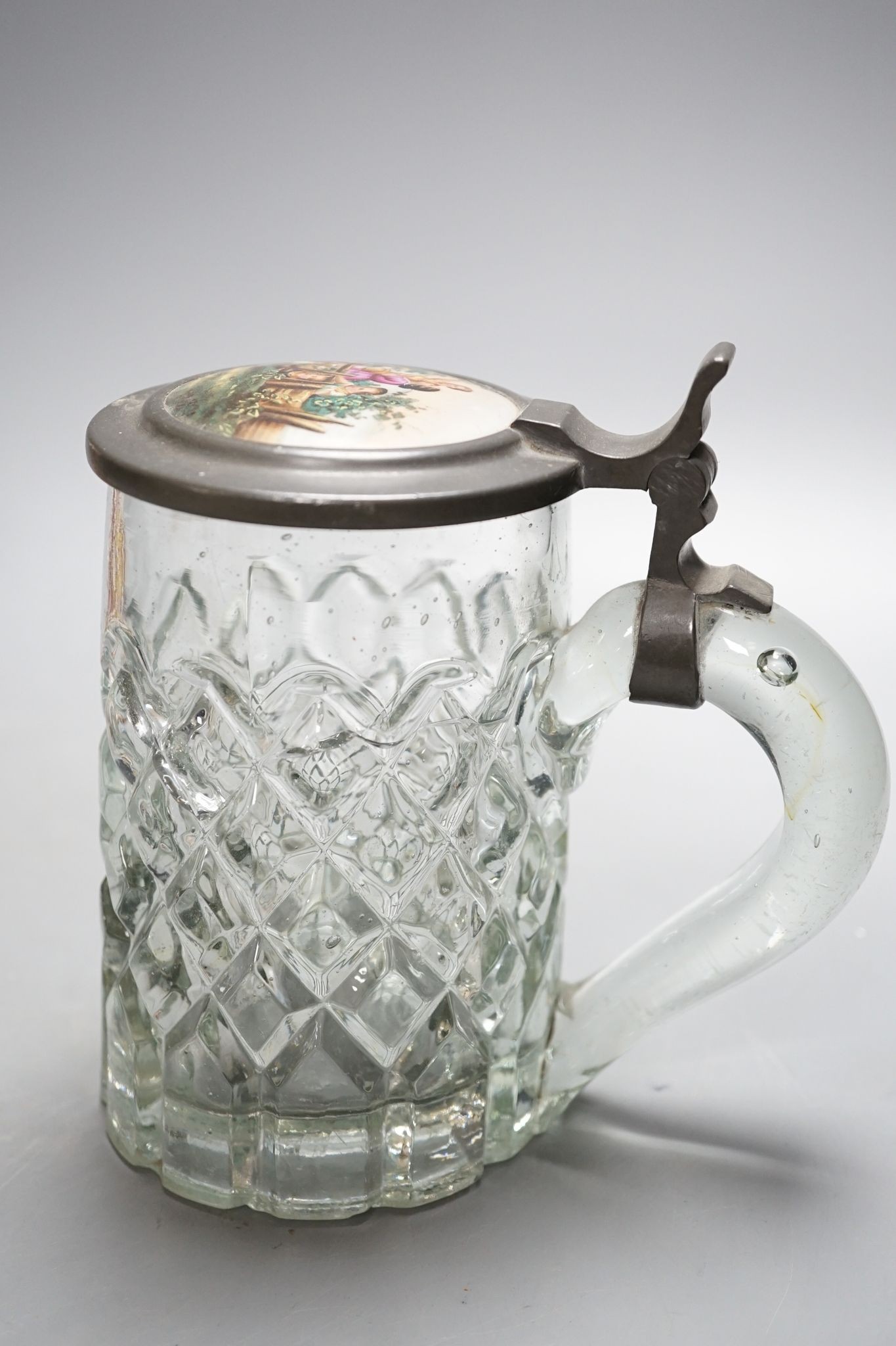 An Italian porcelain lidded tankard and matching jug, together with a cut glass lidded tankard with porcelain inset pewter lid, 22cm